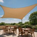 Vela de sombra triangular tensada sobre una zona de comedor de terraza