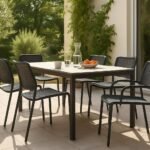 Zona de comedor de terraza amueblada con sillas de jardín apilables alrededor de una mesa