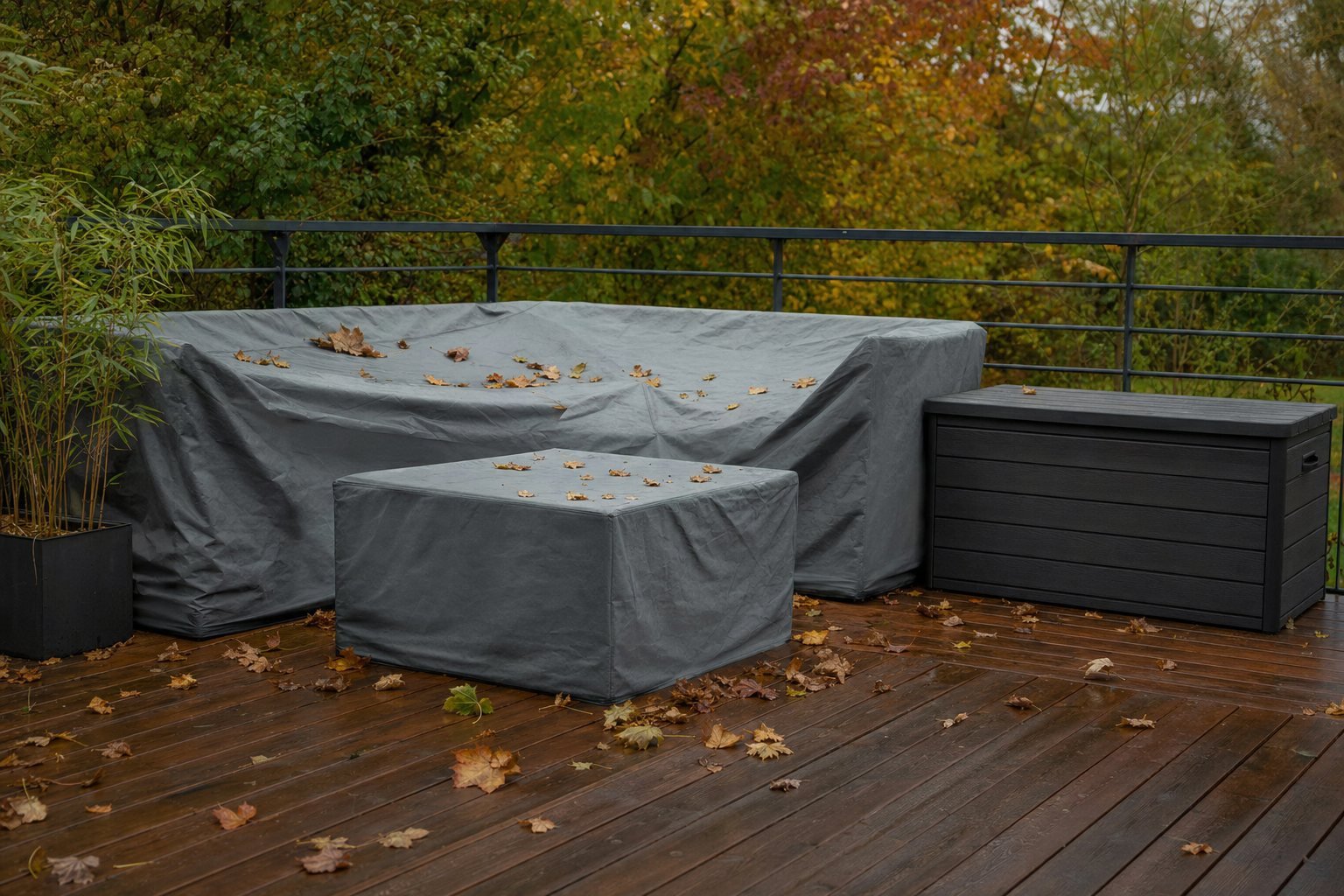 Muebles de terraza cubiertos con funda protectora en otoño junto a un baúl de almacenaje