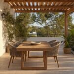 Suelo de baldosas de madera bajo una pérgola con mesa y sillas